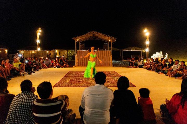 Les voyageurs regardent un spectacle de danse du ventre dans un camp du désert près de Dubaï.