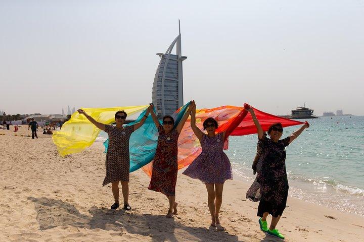 Les voyageurs prennent des photos sur la plage en face de l'hôtel Burj al Arab.