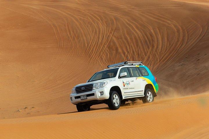Un véhicule hors route emmène les voyageurs dans le désert de Dubaï.